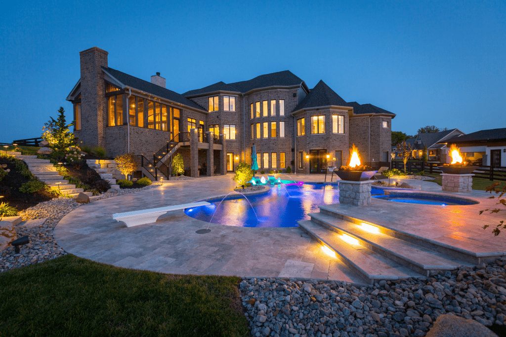 Exterior of custom home with pool at night