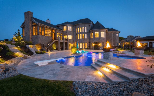 Exterior of custom home with pool at night